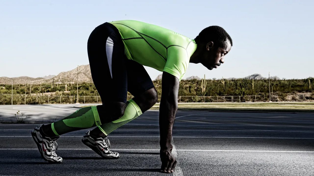 Athlete in starting position on track.