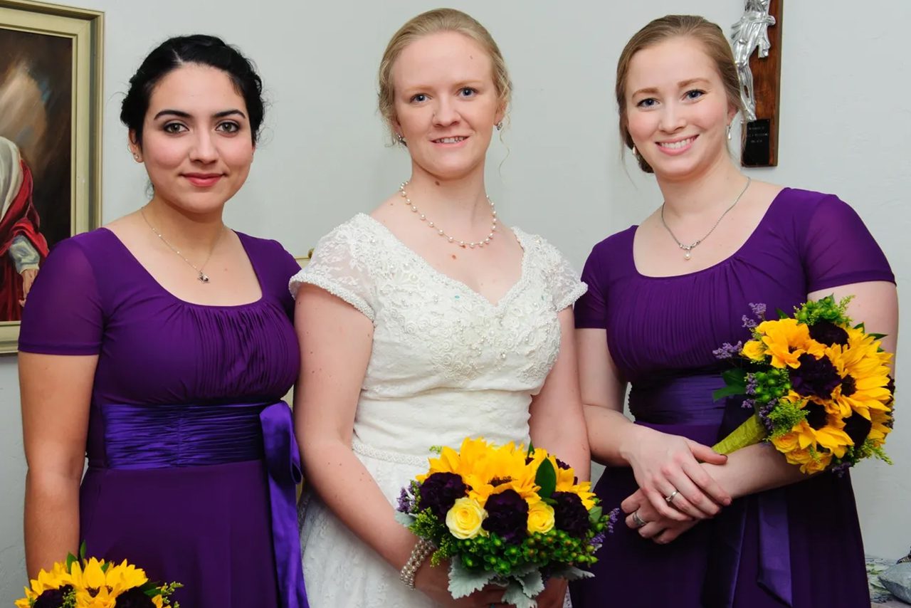 Bride with two bridesmaids in purple dresses.