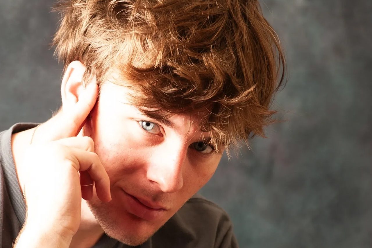 Young man with light brown hair and blue eyes.