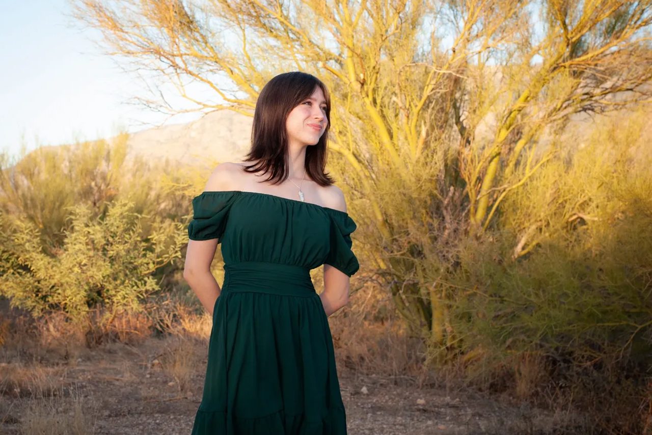 Woman in green dress, desert landscape.